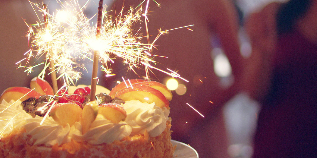 foto de um bolo de aniversário com velas acessas