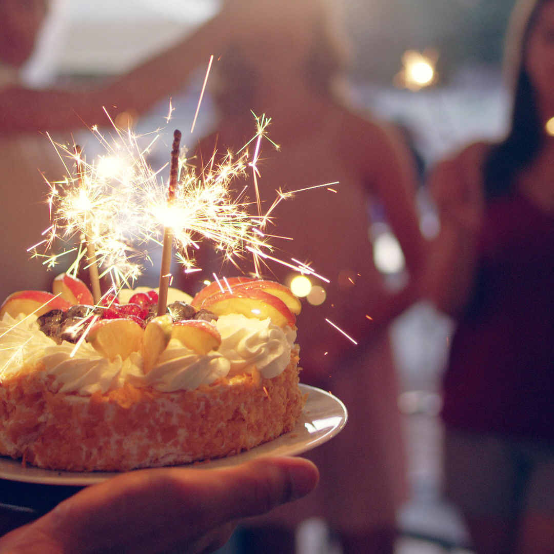 foto de um bolo de aniversário com velas acessas